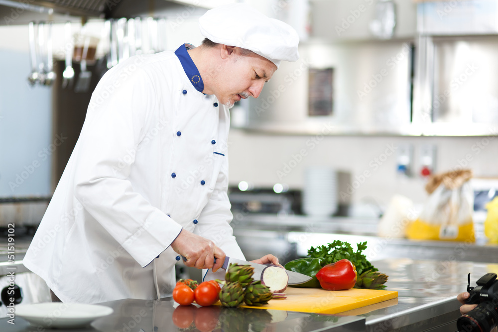 Chef cutting vegetables in a restaurant's kitchen Chef cutting vegetables in a restaurant's kitchen