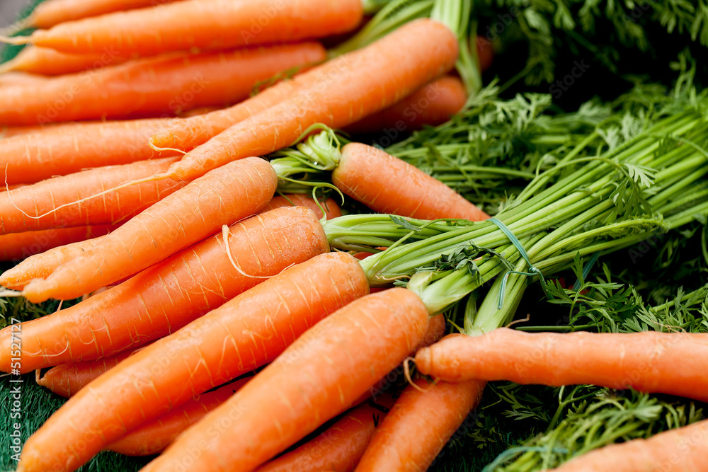 Frische Orangene Karotten gelbe rüben mit grün als Bund auf ei Frische Orangene Karotten gelbe rüben mit grün als Bund auf ei