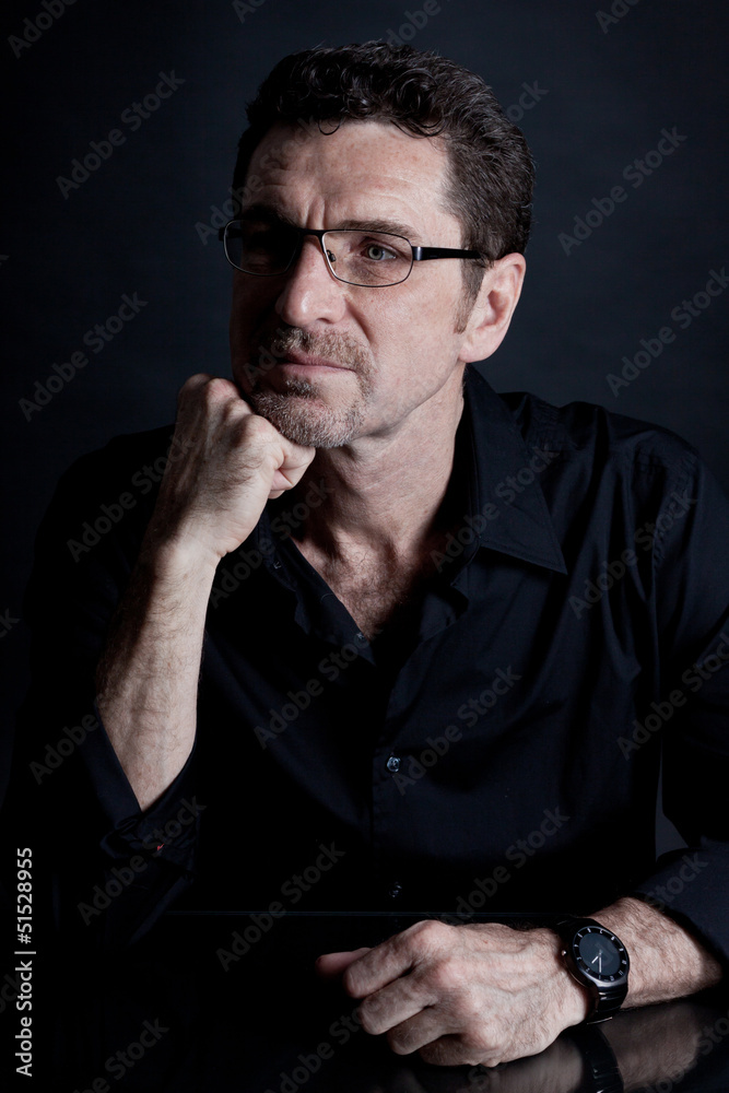 erwachsener mann mit brille schwarzem hemd und bart