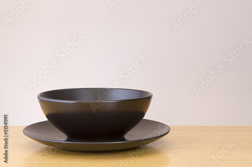 Black plate and bowl on wooden table