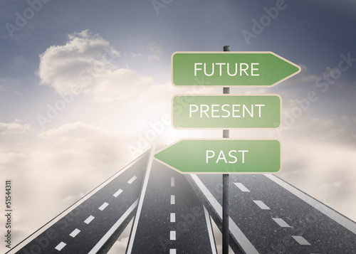 Signposts with future present and past standing on a road