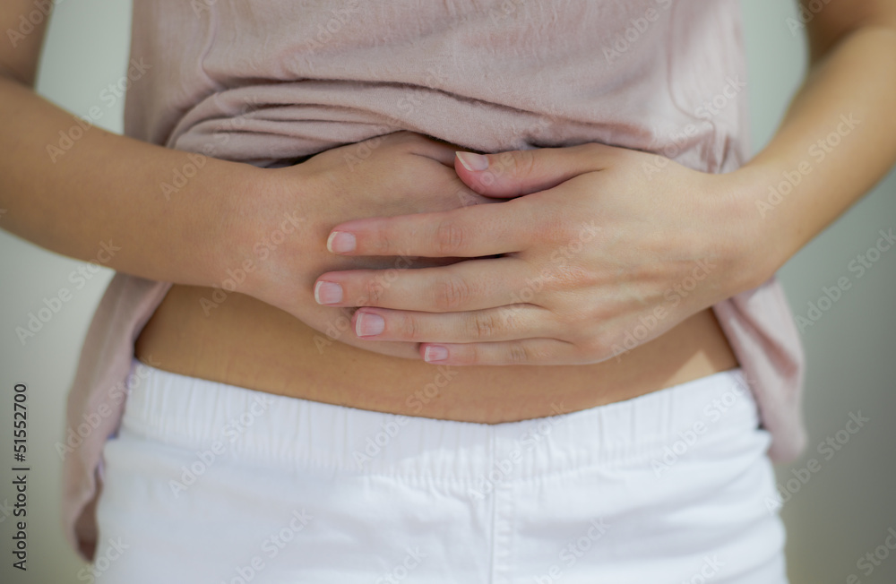 woman with hand on stomach woman with hand on stomach