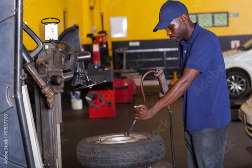 mechanic pumping car tyre