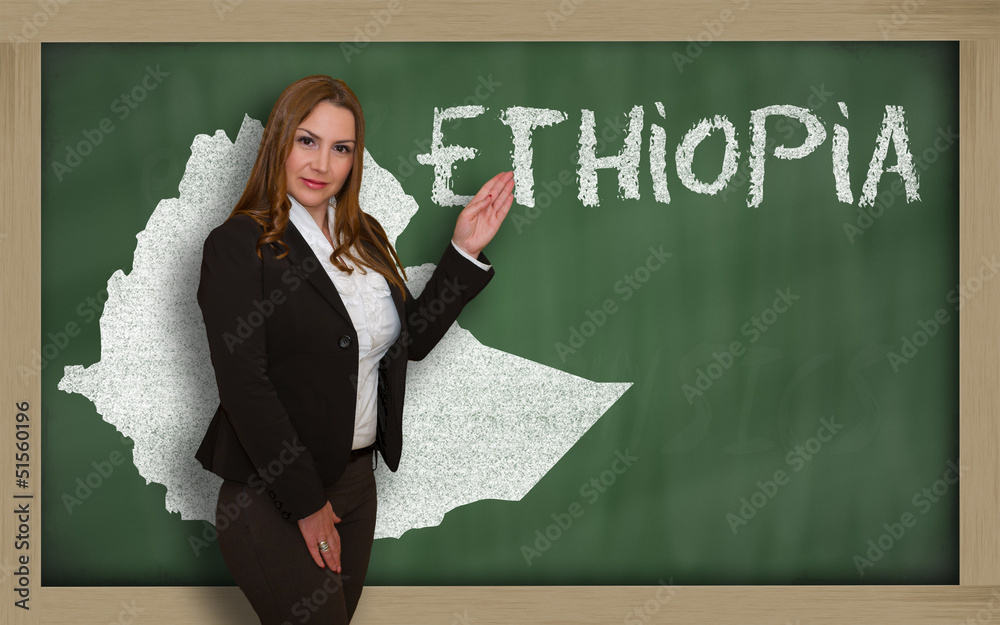 Teacher showing map of ethiopia on blackboard