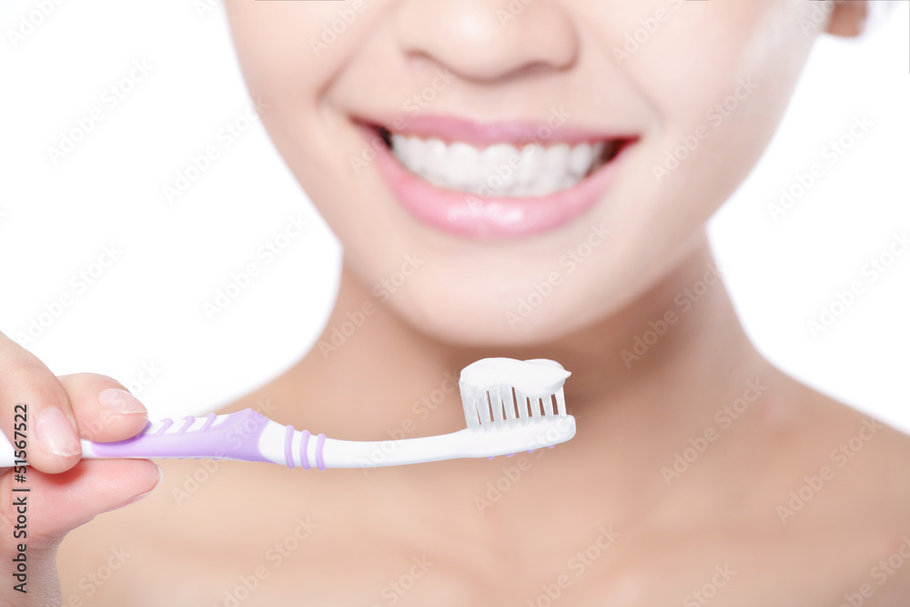 Obraz premium smiling woman cleaning teeth with toothbrush