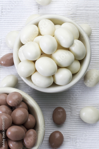 Peanuts coated with dark and white chocolate in small bowls