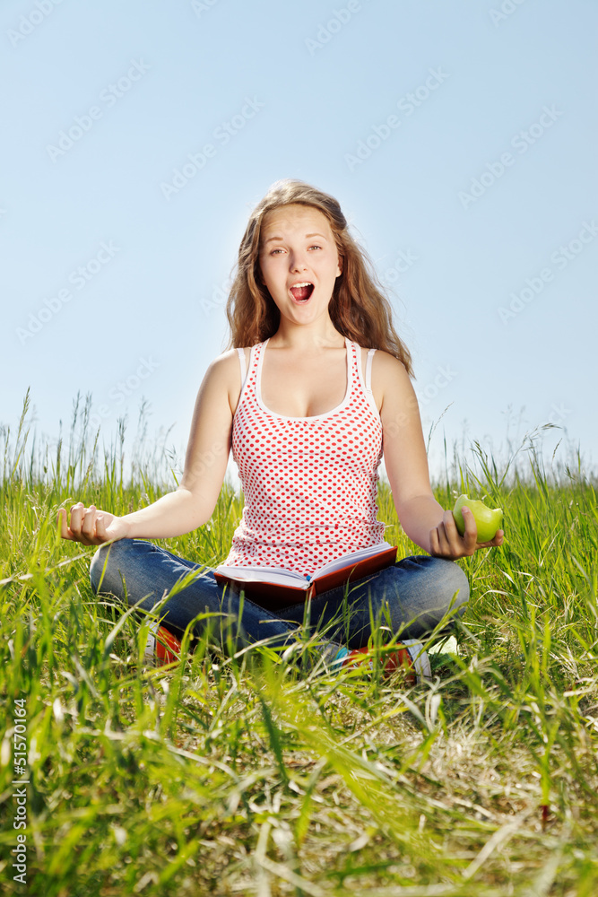 Portrait girl sits on a grass