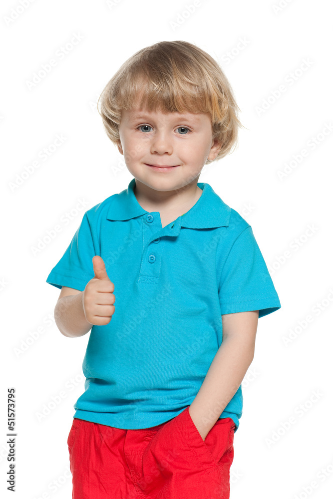 Little blond boy in blue shirt holds his thumb up Little blond boy in blue shirt holds his thumb up