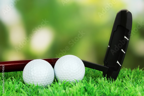Golf balls and driver on green grass outdoor close up
