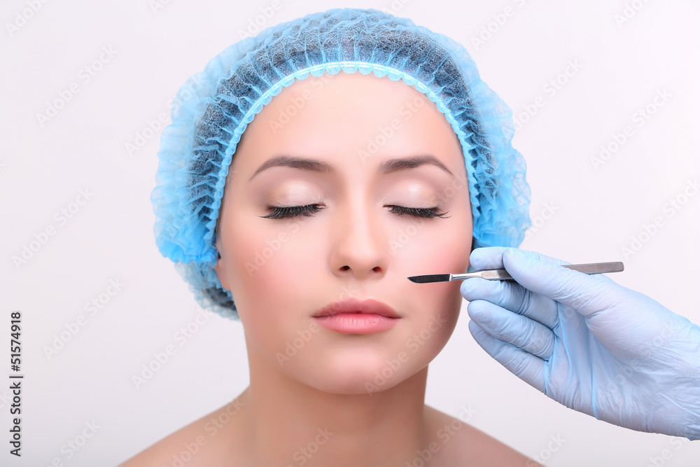 Cosmetic surgery with scalpel on young woman close up Cosmetic surgery with scalpel on young woman close up