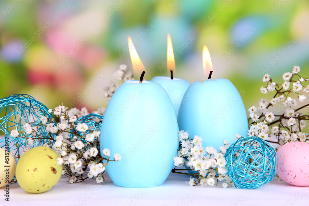 Easter candles with flowers on bright background Easter candles with flowers on bright background