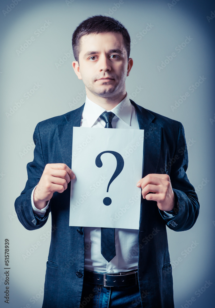 businessman holding a white billboard with a question mark businessman holding a white billboard with a question mark
