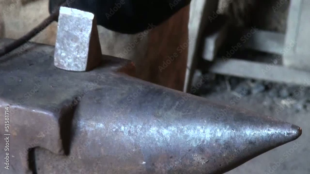 Blacksmith is hammering red-hot piece of iron Blacksmith is hammering red-hot piece of iron