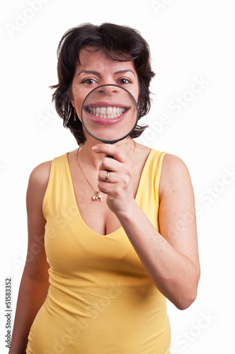 Young woman with magnifying glass at her mouth - Showing teeth