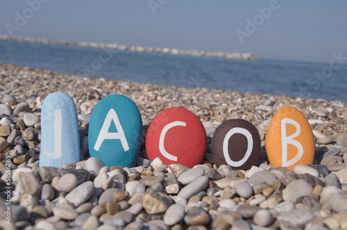 Canvas Print Jacob, male name on colourful stones over pebbles