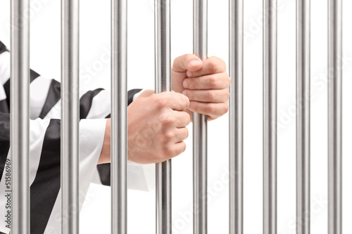 Male holding prison bars