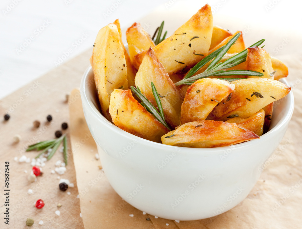 Roasted potatoes with rosemary in a white bowl