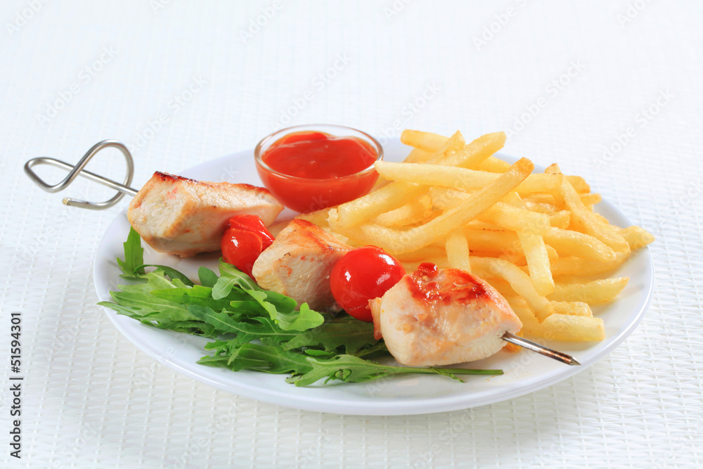 Chicken skewer with fries and ketchup Chicken skewer with fries and ketchup