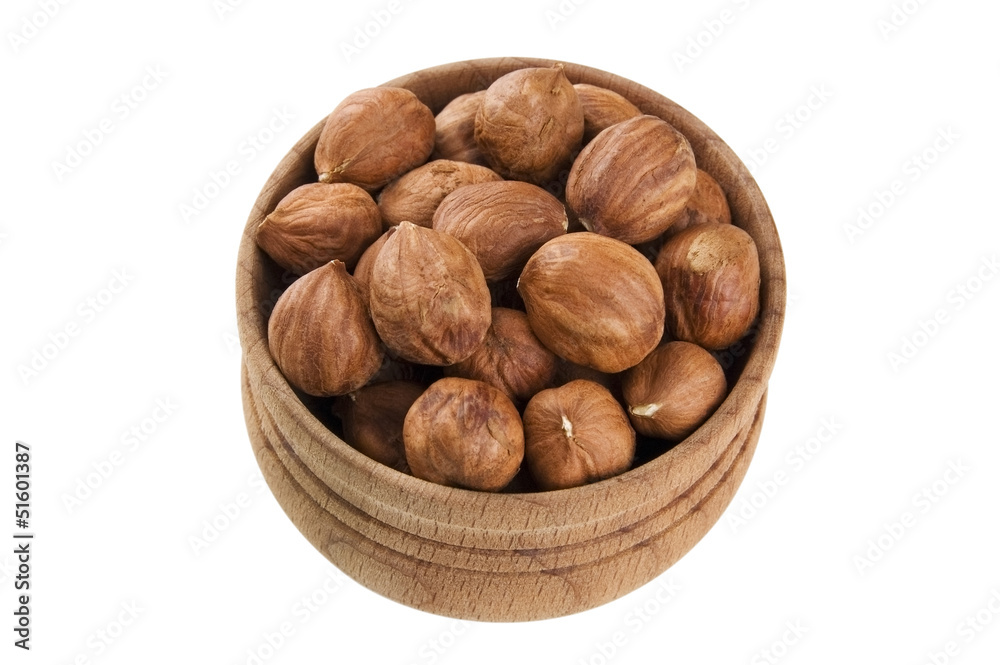 Shelled raw hazelnuts in wooden bowl isolated on white Shelled raw hazelnuts in wooden bowl isolated on white