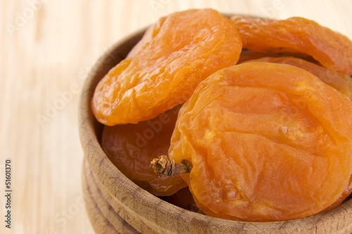 Dried apricots in wooden bowl close up