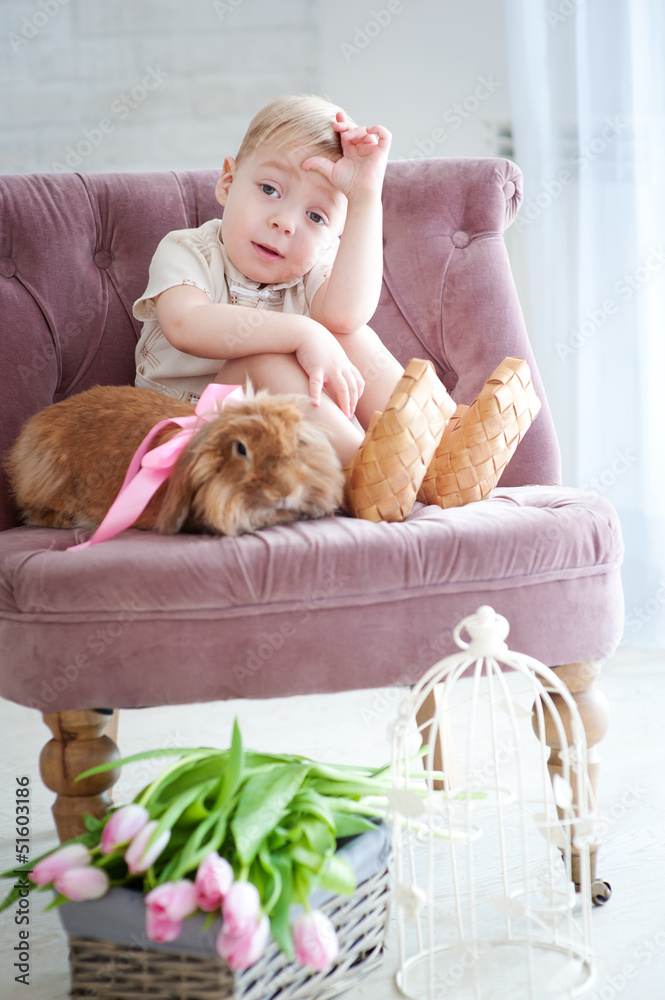 Little boy sitting in a chair with a rabbit Little boy sitting in a chair with a rabbit