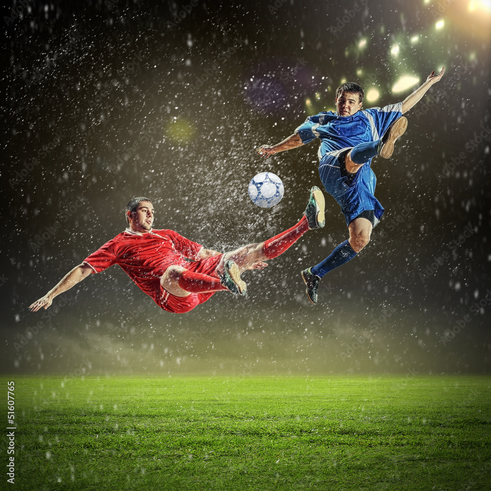 two football players striking the ball two football players striking the ball