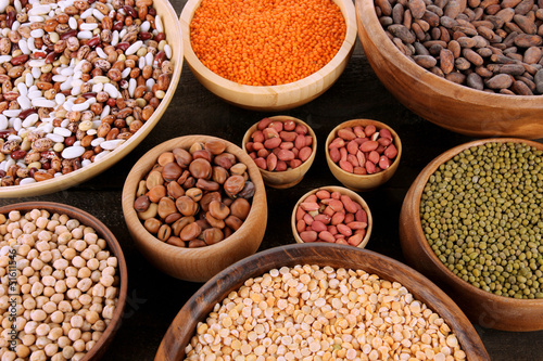 Different kinds of beans in bowls on table close-up