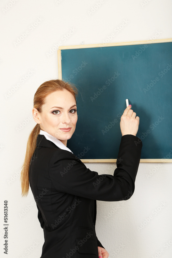 Portrait of teacher woman writing on the chalkboard in Portrait of teacher woman writing on the chalkboard in