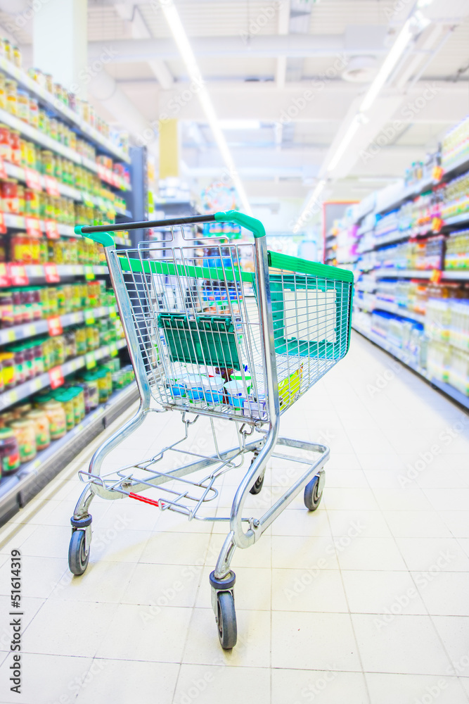 Shopping trolley with some groceries in supermarket Shopping trolley with some groceries in supermarket