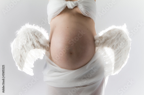 Prgnancy. Woman with wings attached to belly. photo