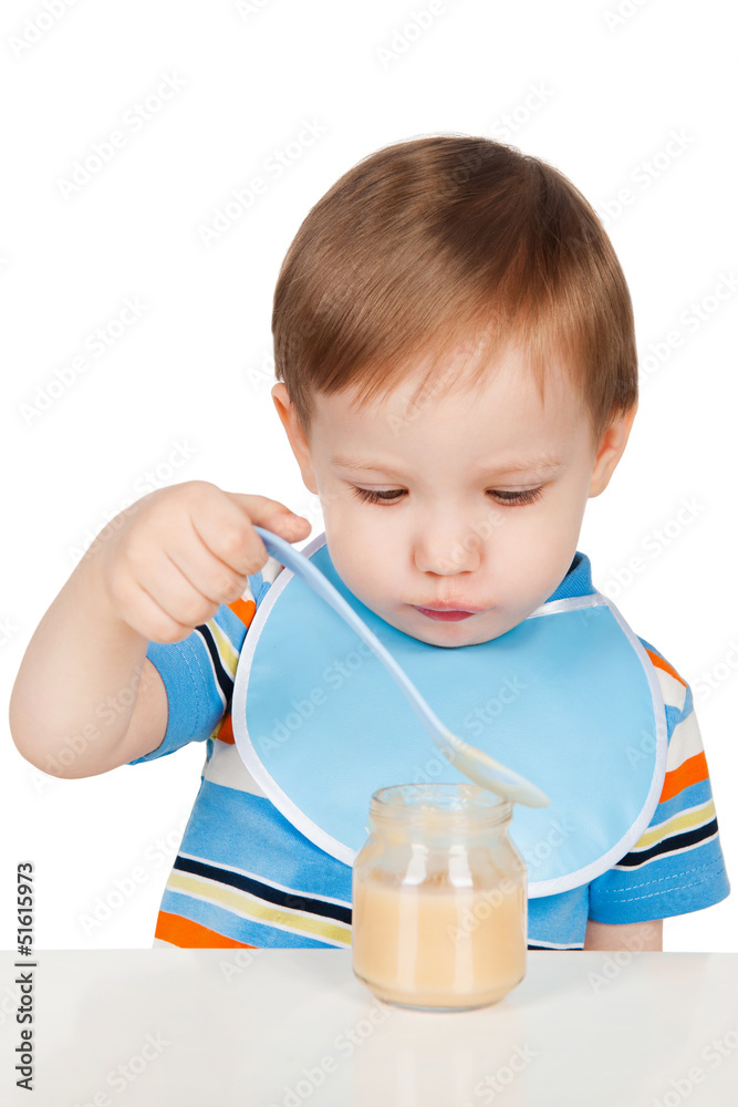 Boy eats with a spoon puree