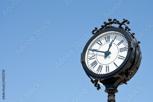 vintage style city clock against blue sky