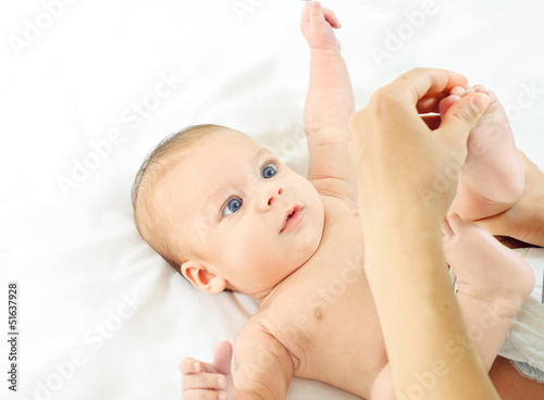 Masseur massaging little baby's feet, shallow focus photo