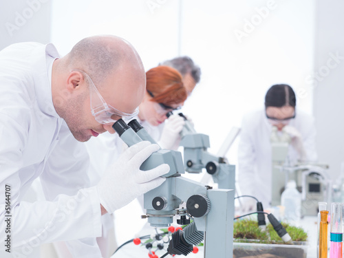 man analyzing under microscope
