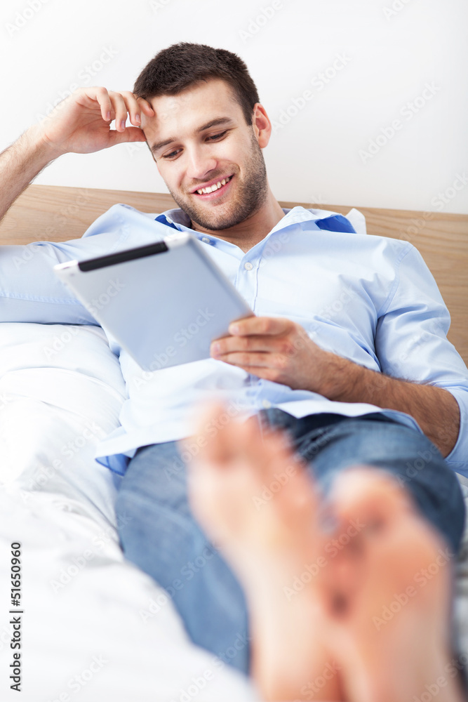 Man relaxing with digital tablet Man relaxing with digital tablet
