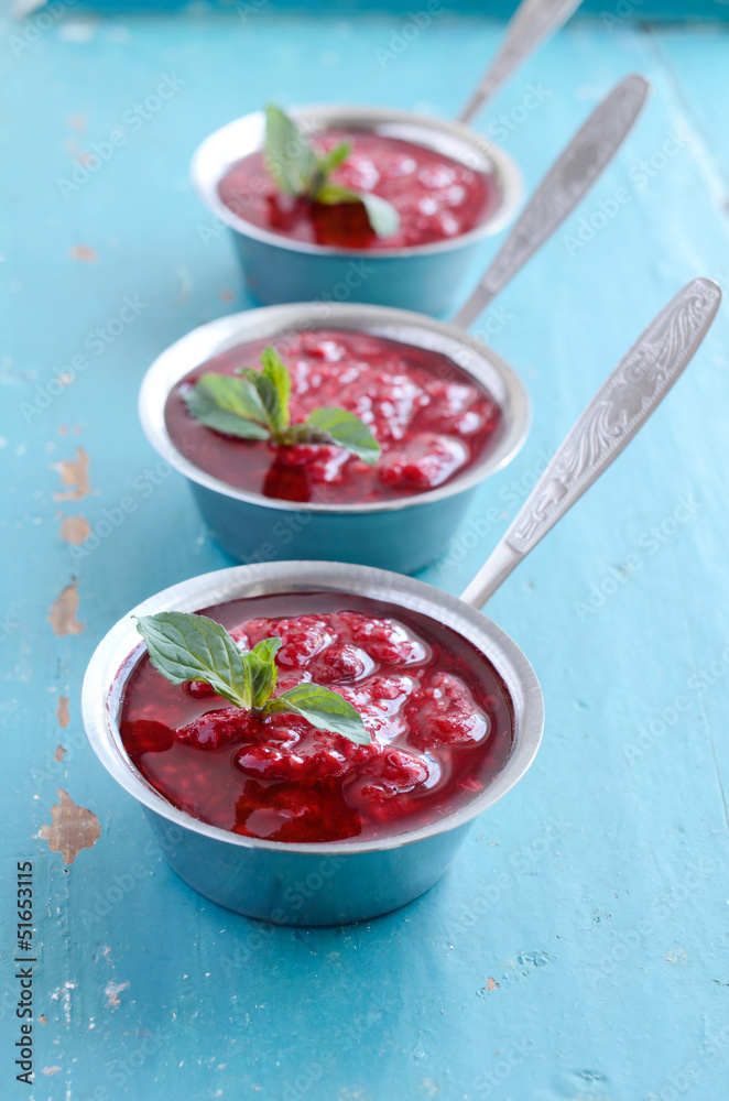 Raspberry sauсe with mint leaf on blue wooden background Raspberry sauсe with mint leaf on blue wooden background