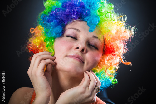 Woman in clown's wig smiling pulling fake hair on the sides
