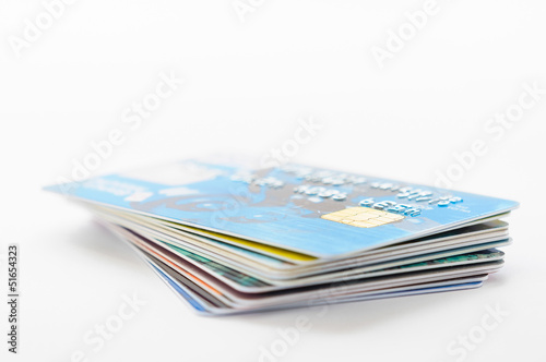 A pile of several colored credit cards on white background