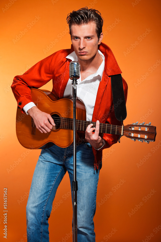Naklejka premium Retro fifties rock and roll singer playing acoustic guitar.