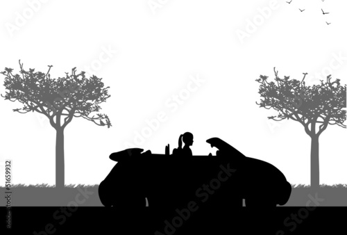 Girl drives a convertible car on the road in spring silhouette