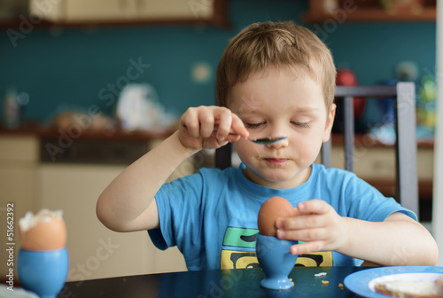 Obraz na płótnie Small happy three year old boy breaks the egg w salonie
