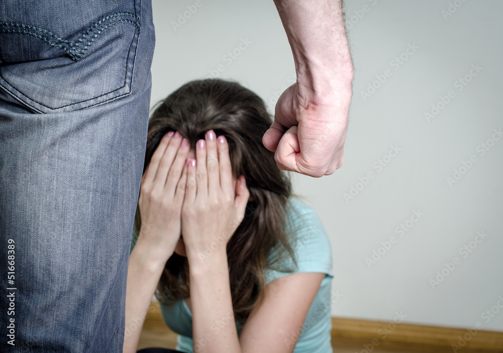 Home violence concept. Frightened woman and men's fist Home violence concept. Frightened woman and men's fist