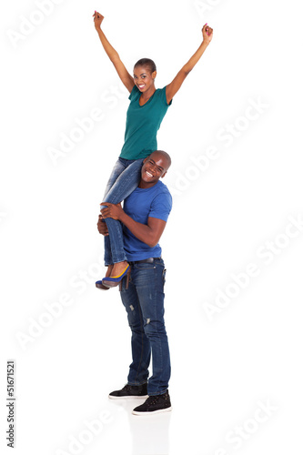happy african woman sitting on her boyfriend's shoulder