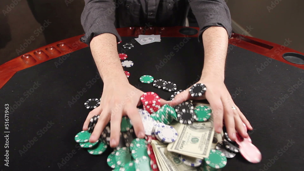 A gambler at a poker table puts his cards down and bets everything he has.
