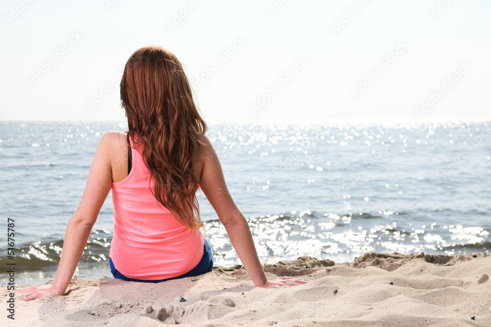 Beach holidays woman enjoying summer sun sitting sand looking ha