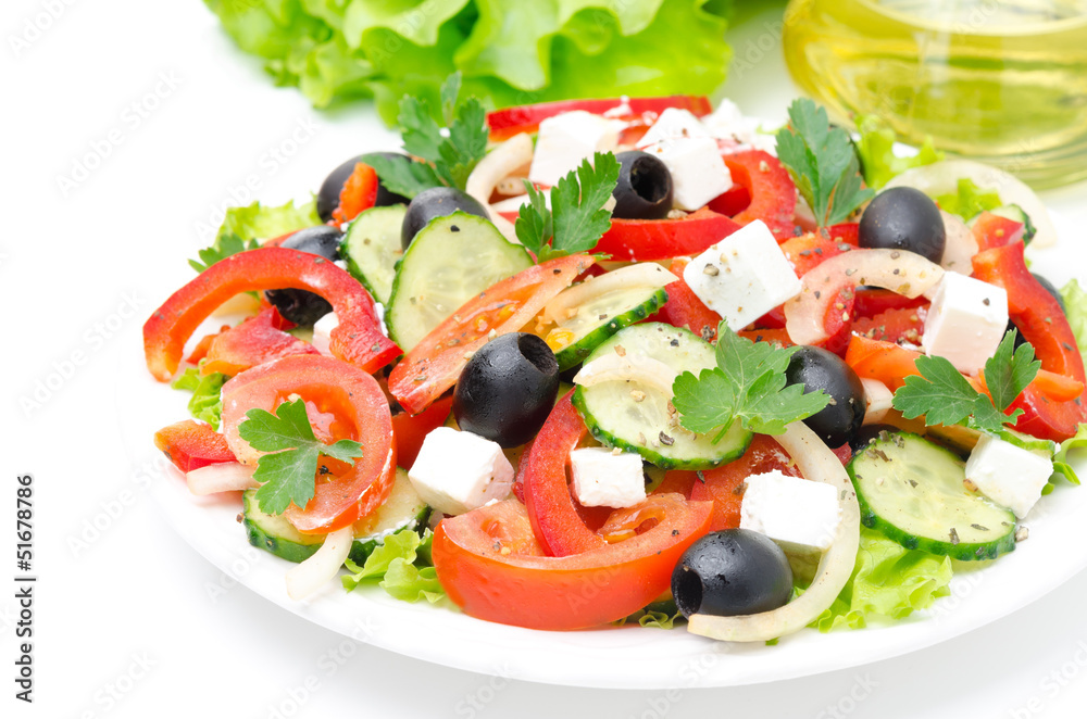 Greek salad with feta cheese, olives and vegetables on white