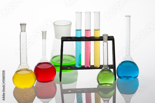 Chemisty set with laboratory glassware filled with various colou