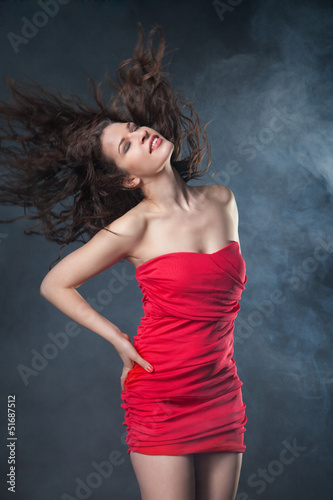 Dancing woman in red dress on black background