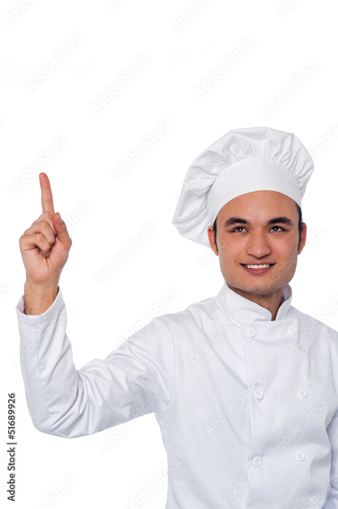 Male chef looking and pointing upwards Male chef looking and pointing upwards