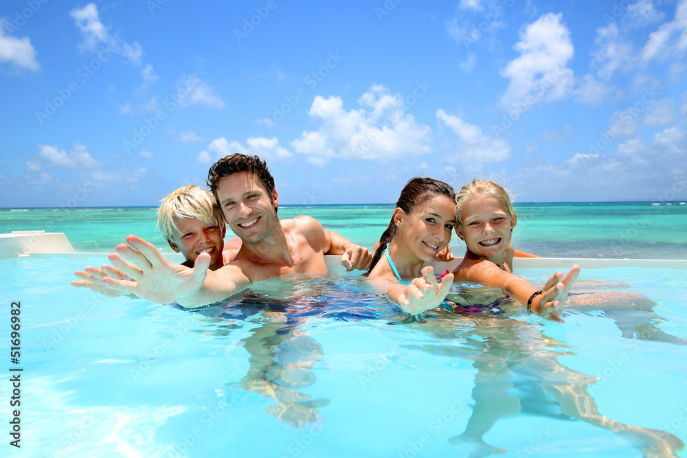 Family of four bathing in swimming pool Family of four bathing in swimming pool